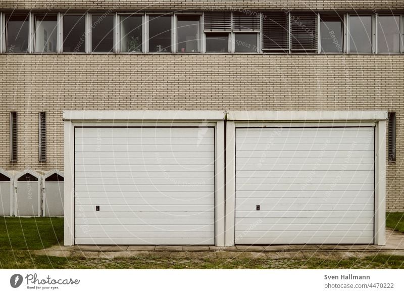 2 Garagen vor einer Hauswand Garagentor trist Tor Menschenleer geschlossen Gebäude Außenaufnahme Einfahrt alt retro Architektur Ausfahrt Zahn der Zeit Wand