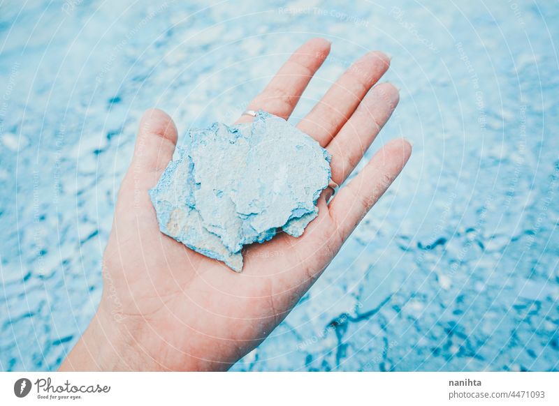 Eine Hand hält ein blaues Stück einer zerbrochenen Mauer Halt Spielfigur geknackt Wand Stock Pool zerbrechlich Zerbrechlichkeit filigran pleite gebrochen ruhen