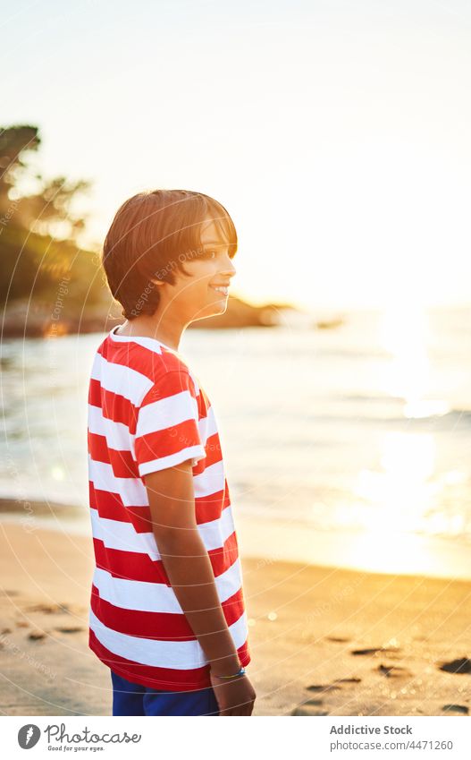 Nachdenklicher Junge am nassen Sandstrand bei hellem Sonnenuntergang Kind Strand MEER winken Ufer Urlaub nachdenklich Küste Natur Wasser Seeküste Meeresufer