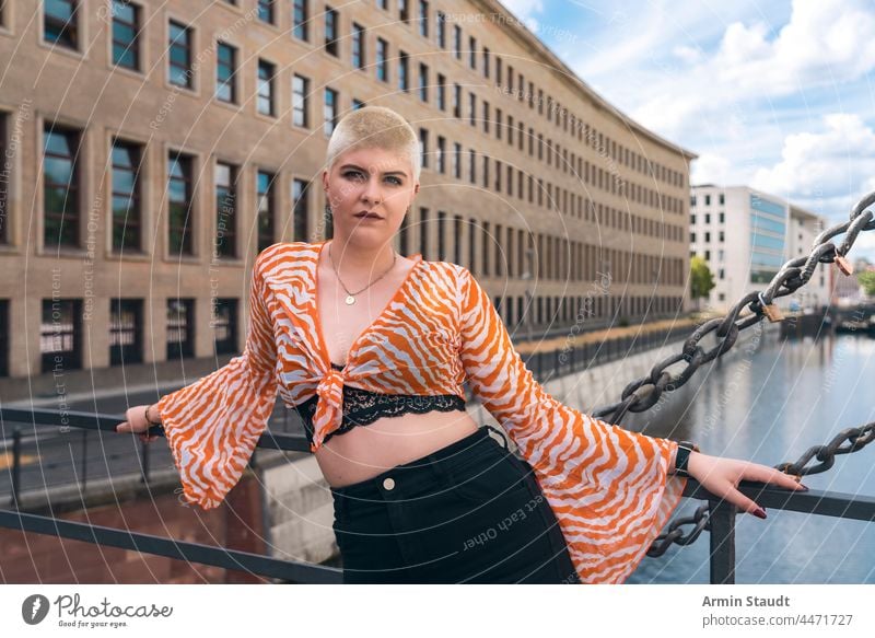 Macht und Schönheit: Porträt einer jungen Frau mit kurzen blonden Haaren auf einer Brücke in Berlin schön Bluse Business Bustier Kanal lässig Kaukasier