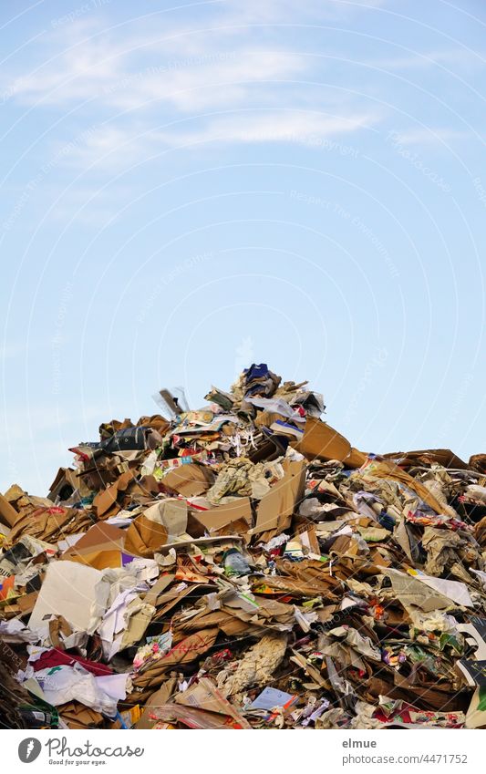 großer Haufen aus altem Papier, Pappe und Karton vor blauem Himmel / Verpackungsmüll / Recycling Müllhaufen Dekowolken Wiederverwendung Wertstoff Wertstoffhof