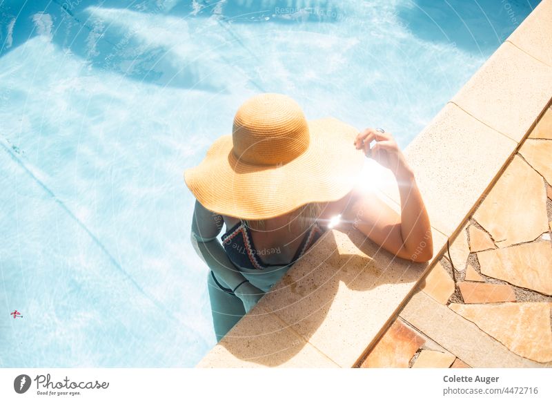 Frau faulenzt in einem Pool Urlaubsstimmung Erholung Sonnenschein Sommer Sonnenbad Sommerhut Schwimmen & Baden Schwimmbad Schwimmsport