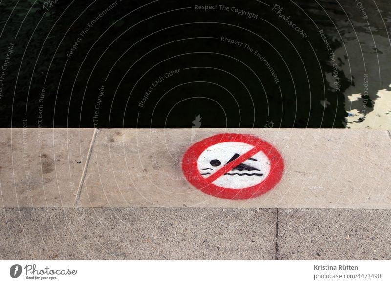 schwimmen verboten symbol auf der kaimauer hinweis warnung zeichen schild ufer hafen promenade hafenbecken kanal wasser gewässer gefahr gefährlich sicherheit