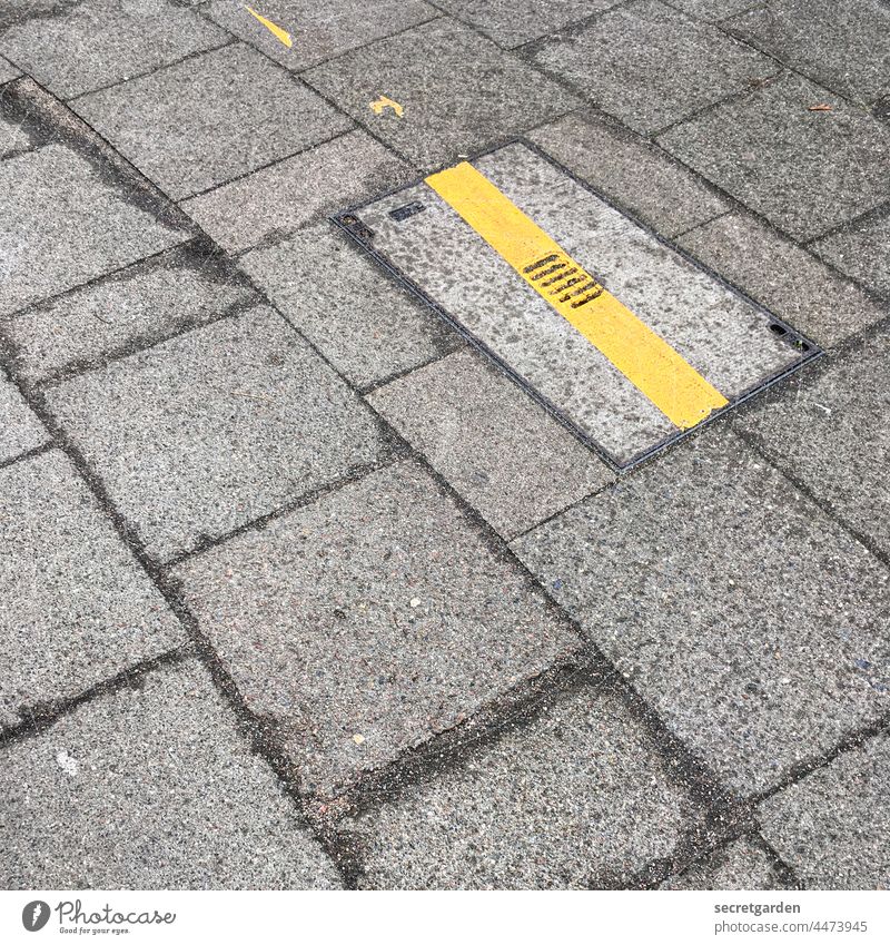 Auf die schlanke Linie achten Markierung Boden Fussboden Pflastersteine öffentlicher Raum minimalistisch gelb grau Bodenbelag Gulli gullideckel