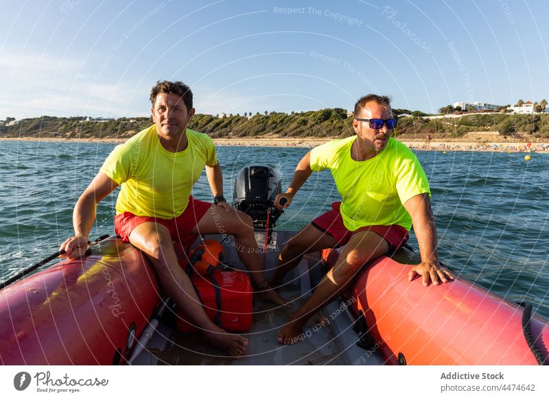 Männliche Rettungsschwimmer auf einem aufblasbaren Motorboot Männer Boot Kontrolle MEER Sicherheit Segel behüten Schwimmer männlich Meeresufer Rippeln Wasser