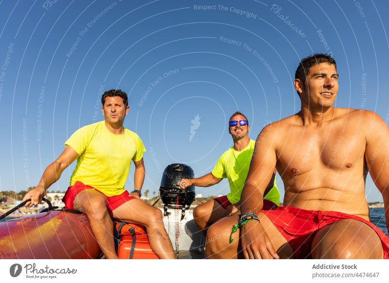 Männliche Rettungsschwimmer auf einem aufblasbaren Motorboot Männer Boot Kontrolle MEER Sicherheit Segel behüten Schwimmer männlich Meeresufer Rippeln Wasser