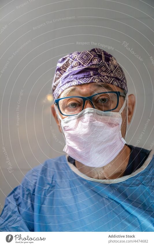 Oberarzt in OP-Anzug und Maske in der Klinik Mann Chirurg Medizin alt Mundschutz professionell Operation Porträt Beruf Leckerbissen männlich Arzt Krankenhaus