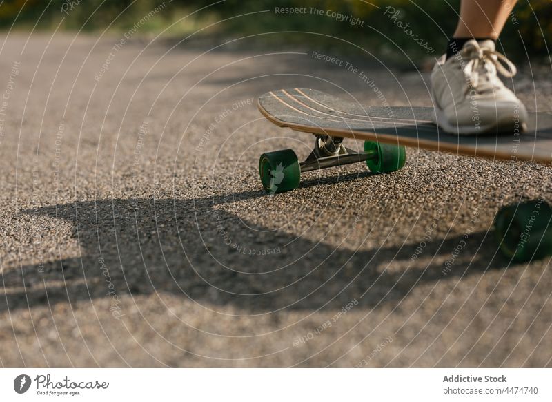 Anonyme Frau fährt Longboard auf einer asphaltierten Straße Mitfahrgelegenheit Aktivität Hobby genießen Freizeit Natur Gleichgewicht wolkig Training Hügel