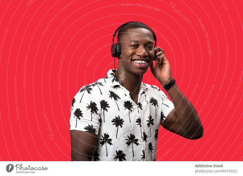 Schwarzer Mann genießt Musik mit modernen Kopfhörern zuhören Hobby Drahtlos unterhalten froh genießen Vergnügen männlich Glück Freude Apparatur Klang Gesang