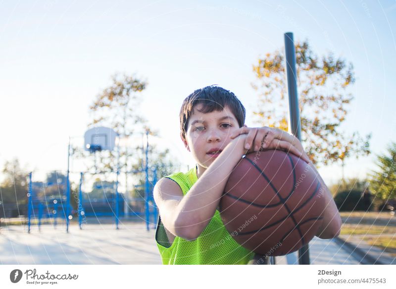 Junger Teenager mit ärmellosem Oberkörper steht auf einem Basketballplatz und lächelt in die Kamera Lächeln Gericht Spieler wirklich Jugend Stehen passen Glück