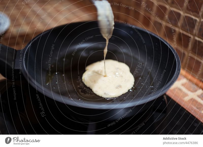 Crop-Frau brät Pfannkuchen in der Pfanne braten Herd Küche Koch Prozess lecker Lebensmittel heimwärts vorbereiten selbstgemacht Rezept Schalen & Schüsseln Glas
