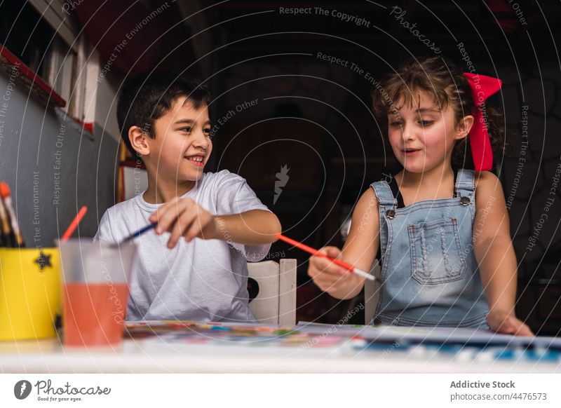 Fröhliche Kinder malen am Tisch Farbe Hobby Kunst Pinselblume Kindheit Papier Handwerk Wasserfarbe positiv farbenfroh heiter Inhalt Licht kreativ niedlich