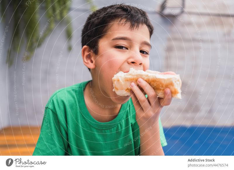 Hungriger Junge isst Hot Dog Kind Hotdog essen Brot Lebensmittel Kindheit Snack Appetit & Hunger Biss hungrig Licht Raum bezaubernd niedlich geschmackvoll