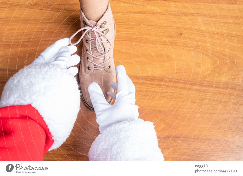 Der Weihnachtsmann hilft einem Mädchen beim Binden der Schnürsenkel Unterstützung Bonden lässig Kind Kindheit Claus abschließen Tag Ermutigung Familie