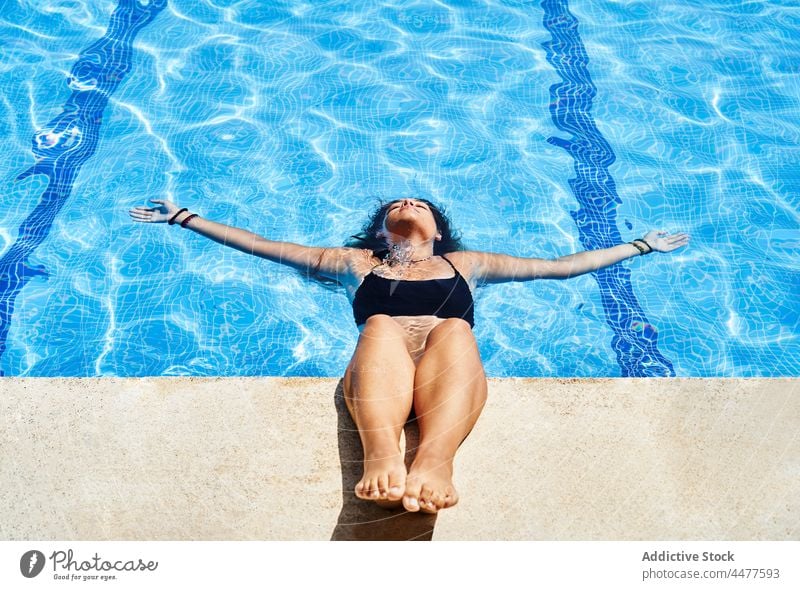 Attraktive Frau im Badeanzug im Pool Wasser Bikini Sommer schwimmen Resort Urlaub Sonnenlicht Beckenrand charmant jung hispanisch ethnisch Feiertag aqua ruhen