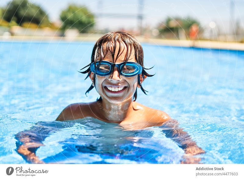 Fröhlicher Junge mit Schwimmbrille Pool Wasser Glück Lächeln Sommer Kind Schutzbrille nasses Haar schwimmen Kindheit froh Freude Wochenende Urlaub tagsüber Spaß