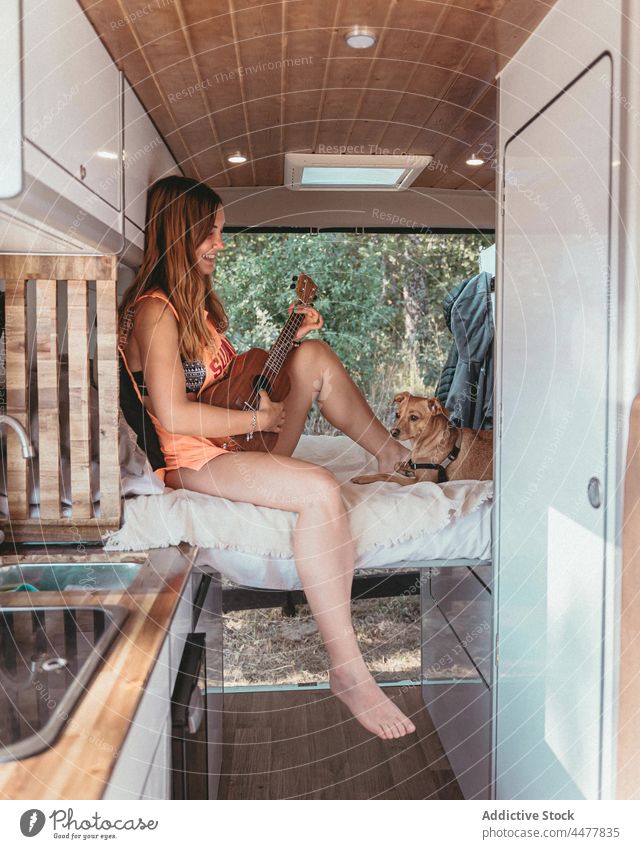Reisender spielt Ukulele im Wohnmobil Frau Kleintransporter spielen Hund reisen Ausflug Zusammensein Spanien geparkt heiter akustisch Musik Instrument Haustier
