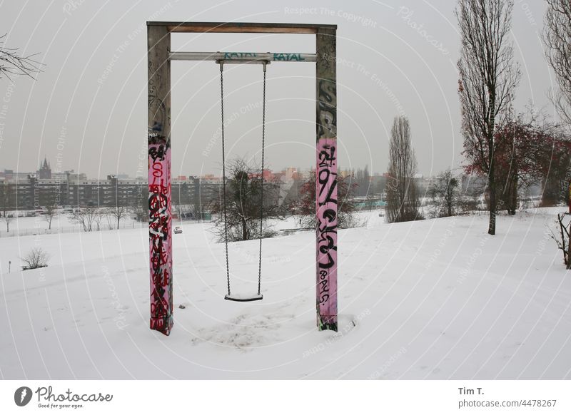 eine Schaukel im Winter und Schnee . mauerpark Berlin Prenzlauer Berg Stadt Außenaufnahme Hauptstadt Stadtzentrum Menschenleer Graffiti Spielplatz