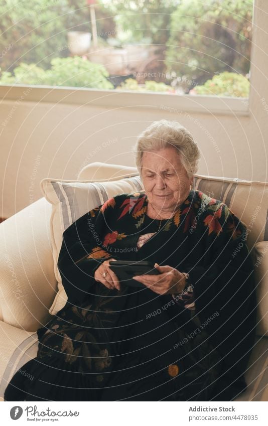 Ältere Frau liest digitales Buch lesen e-Buch Sofa zu Hause ruhen Tablette Wochenende Wohnzimmer Fokus Hobby interessant Senior gealtert älter