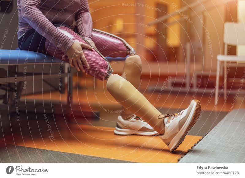 Frau mit Beinprothese Physiotherapie Tatkraft Wiederherstellung Rehabilitation Stärke Training Beine Übung Fitness Sport Gesundheit Körper Fitnessstudio aktiv