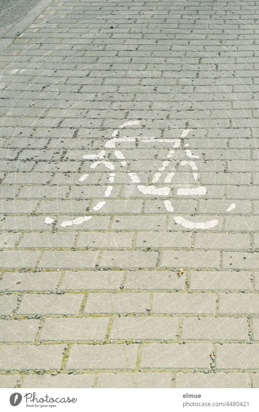 Reste eines auf Pflastersteine aufgemalten Fahrrades / Radweg / Piktogramm Fahrradbild Fahrbahnmarkierung Verkehr Fahrtrichtung Radfahren Straßenverkehr StVO