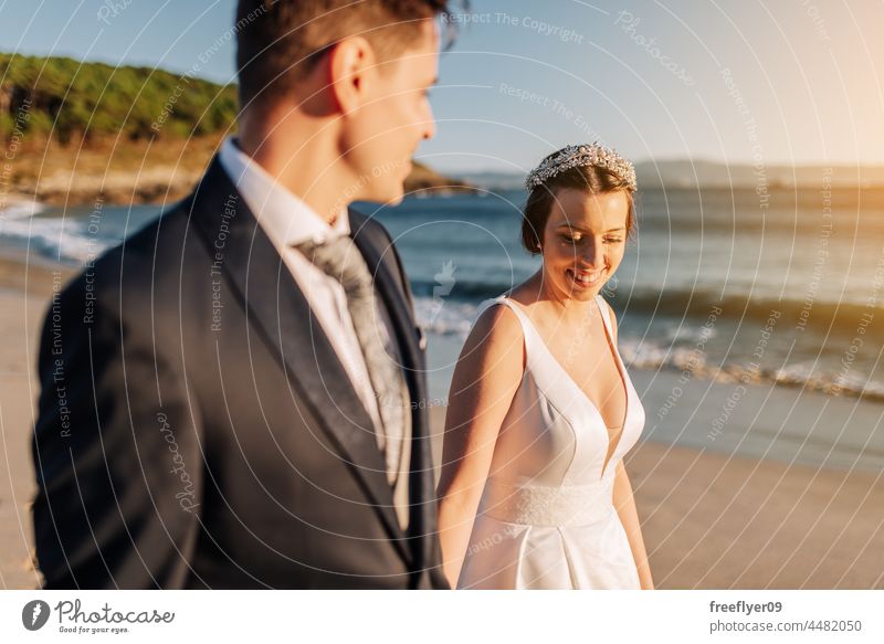 Ein Ehepaar geht am Strand spazieren Hochzeit Ehemann Ehefrau Bekleidung Liebe Textfreiraum Meer Sonnenuntergang Paar heterosexuell Braut striegeln Wald Baum