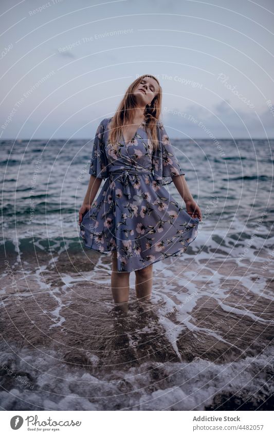 Frau in elegantem Kleid am Meeresufer stehend Sommer Abend Strand trendy Sonnenuntergang MEER Himmel Freude Glück Stil Küste Wasser Felsen Seeküste froh
