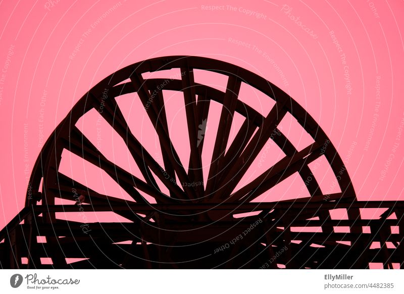 Abstrakte Aufnahme der Zeche Radbod in Hamm. Schwarze Silhouette eines Rads vor einem pinken Hintergrund. Zeche Radbod Hamm abstrakt Industrie Industrieanlage