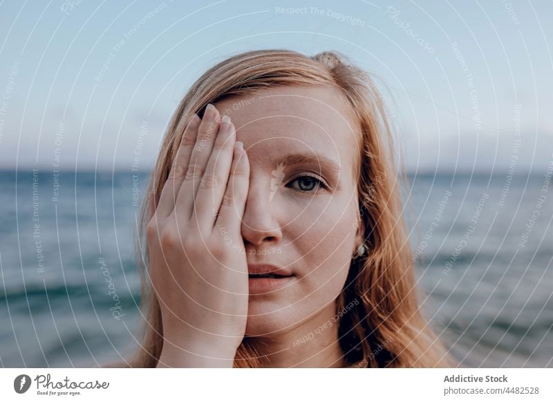 Junge Frau bedeckt Gesicht mit Hand Sommer Meeresufer Abend Windstille MEER Porträt Natur Wasser Sonnenuntergang friedlich Strand jung Ufer Küste Tierhaut