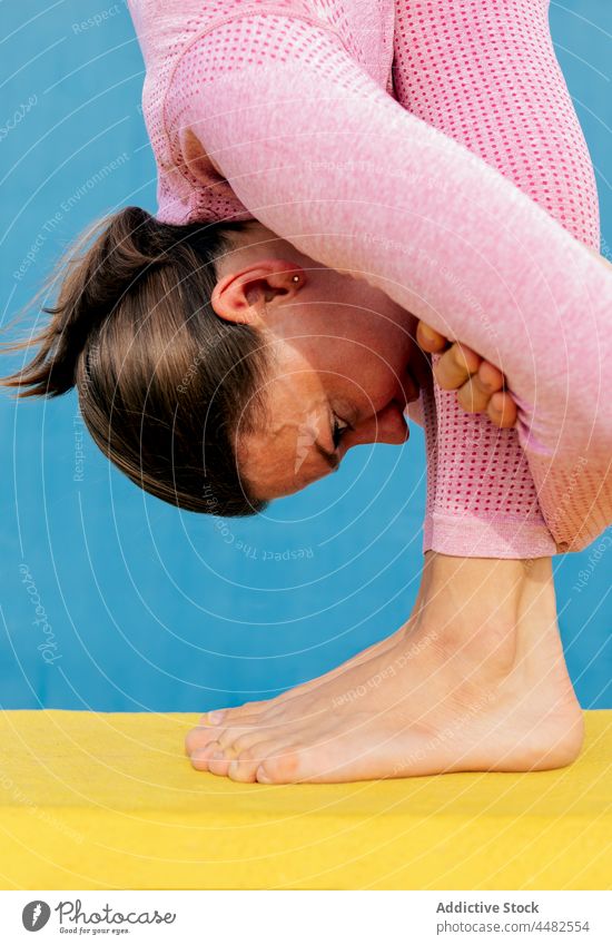 Flexible Frau übt Gymnastik auf einer Matte Training Dehnung Unterlage Fitness passen beweglich Sportbekleidung Wohlbefinden schlank Übung üben physisch