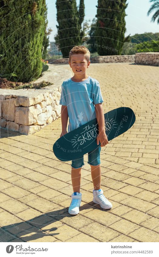 Vorschulkind hält im Park ein Skateboard in den Händen Kind Sport Sommer Familie Attrappe Junge Natur Lifestyle Freizeit im Freien T-Shirt Schulkind jung Skater