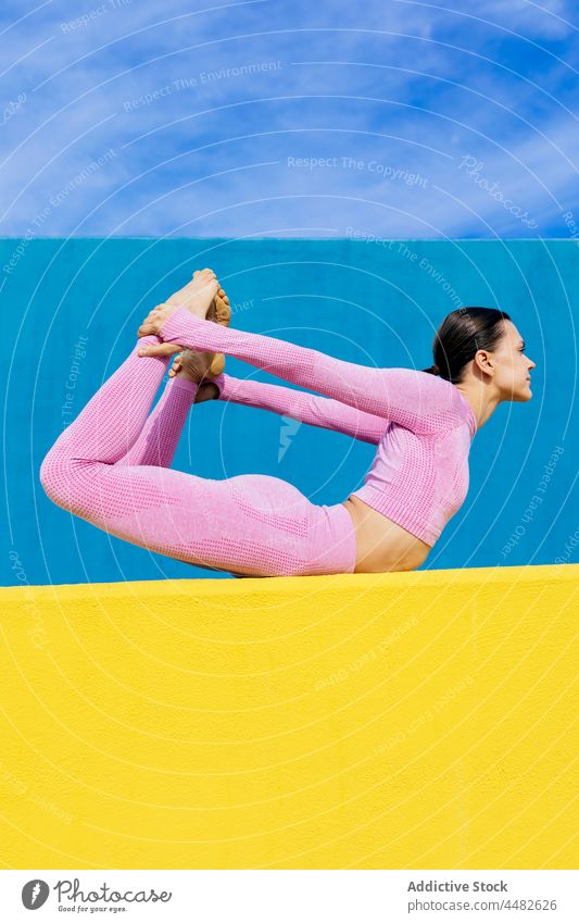 Flexible Frau in Bogenstellung auf der Matte üben Yoga Training Schleife Dehnung dhanurasana Unterlage Gleichgewicht Konzentration Sportbekleidung positionieren