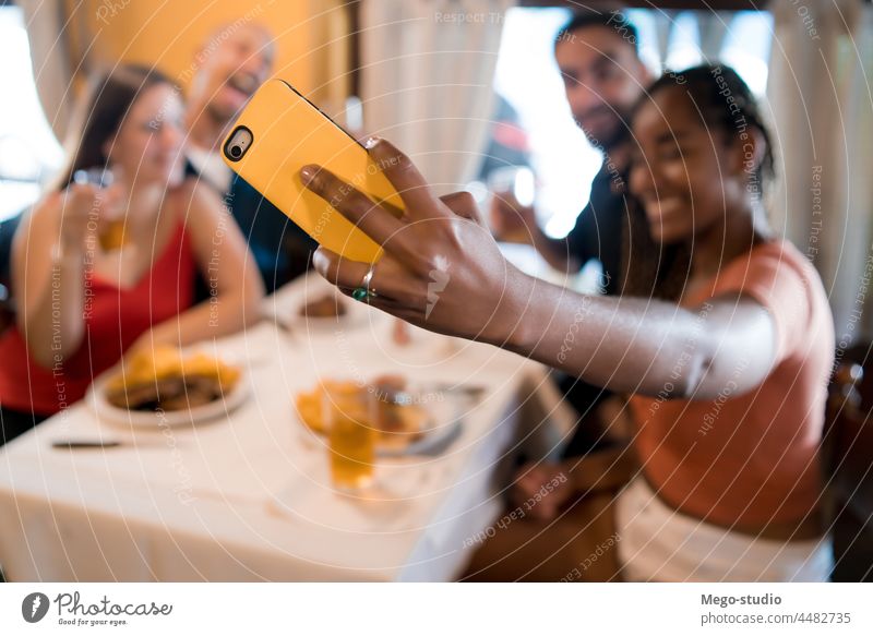 Eine Gruppe von Freunden macht ein Selfie mit einem Mobiltelefon in einem Restaurant. Zusammensein trinken Bier Mobile Telefon Lebensmittel Mahlzeit