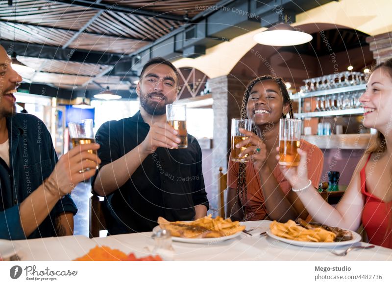 Eine Gruppe von Freunden genießt eine gemeinsame Mahlzeit in einem Restaurant. Zusammensein trinken Bier Bar Freundschaft im Innenbereich Genuss Spaß jung Glück