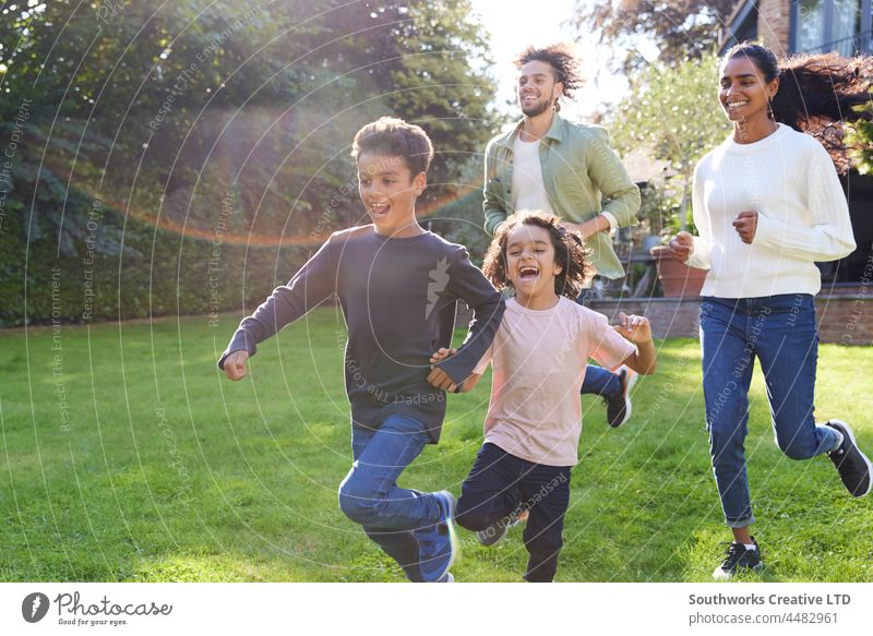 Familie läuft auf dem Rasen vor dem Haus gemischte Rasse asiatisch laufen Junge Mutter Vater Sohn Bruder im Freien Tag vier Menschen Porträt authentisch