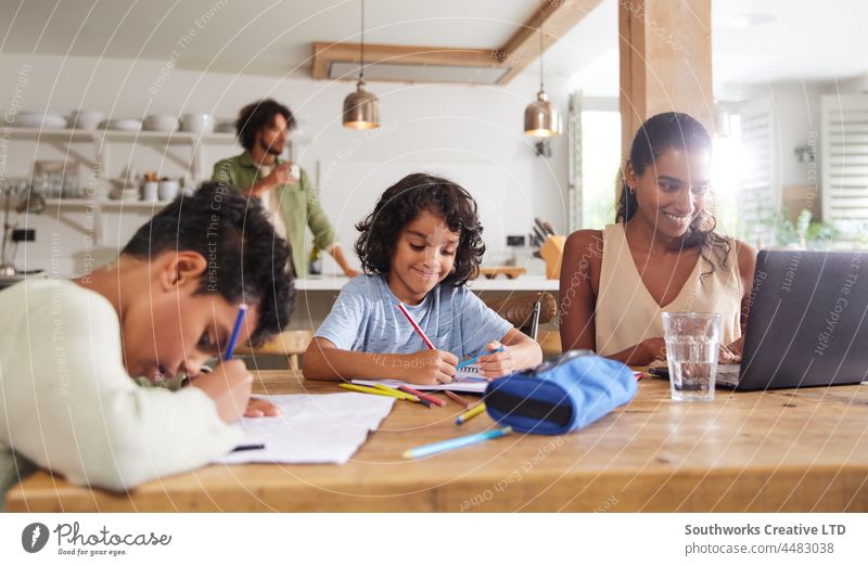 Jungen machen Hausaufgaben, während die Mutter von zu Hause aus arbeitet gemischte Rasse Arbeit Kind Opferbereitschaft Bildung Heimschule lernen im Innenbereich