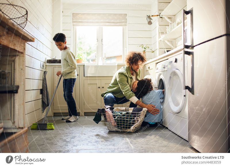 Zwei Jungen helfen ihrem Vater bei der Hausarbeit gemischte Rasse Kind Hilfsbereitschaft Küche Hausarbeiten Kehren Besen Wäscherei im Innenbereich Tag heimwärts