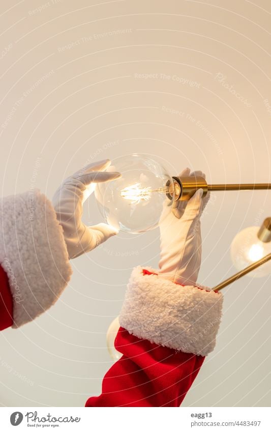 Der Weihnachtsmann wechselt eine Glühbirne Arme Assistent Bierglas Knolle zu feiern sich[Akk] ändernd jauchzen Weihnachten weihnachtszeit Claus Cocktails cool