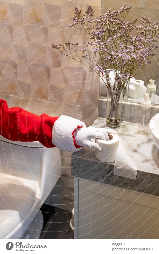 Der Weihnachtsmann benutzt Toilettenpapier in der Toilette eines Hauses Bad Weihnachten Weihnachtsdekoration weihnachtszeit Claus Nahaufnahme Komiker Konzept