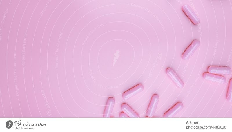 Top view rosa Kapseln Pille auf rosa Hintergrund. Gesundheitspflege Web-Banner. Vitamine und Nahrungsergänzungsmittel für Frauen Konzept. Pharmazeutische Industrie. Brustkrebs oder Frau Gesundheitsthemen. Gesundes Leben.