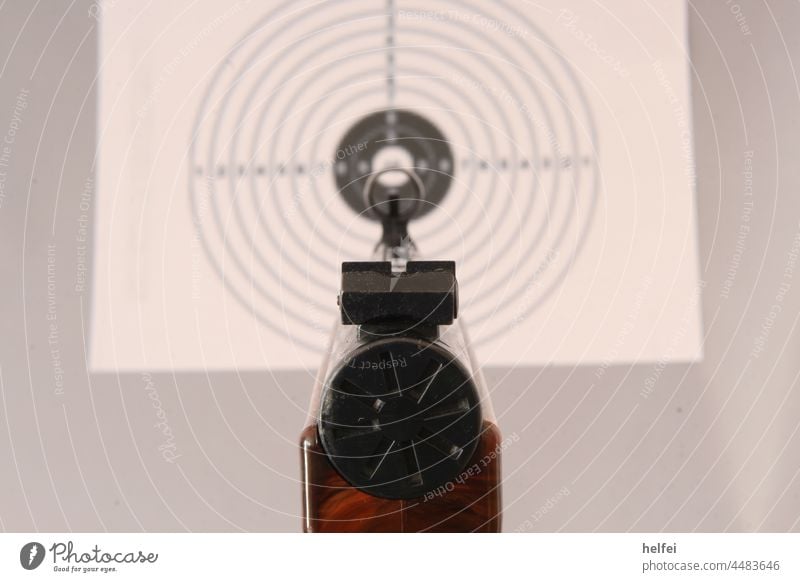 Luftpistole zielt auf Zielscheibe mit Blick durch Kimme und Korn Luftpistole mit Zielscheibe. waffe diabolo zielscheibe geschoss projektil schießen munition