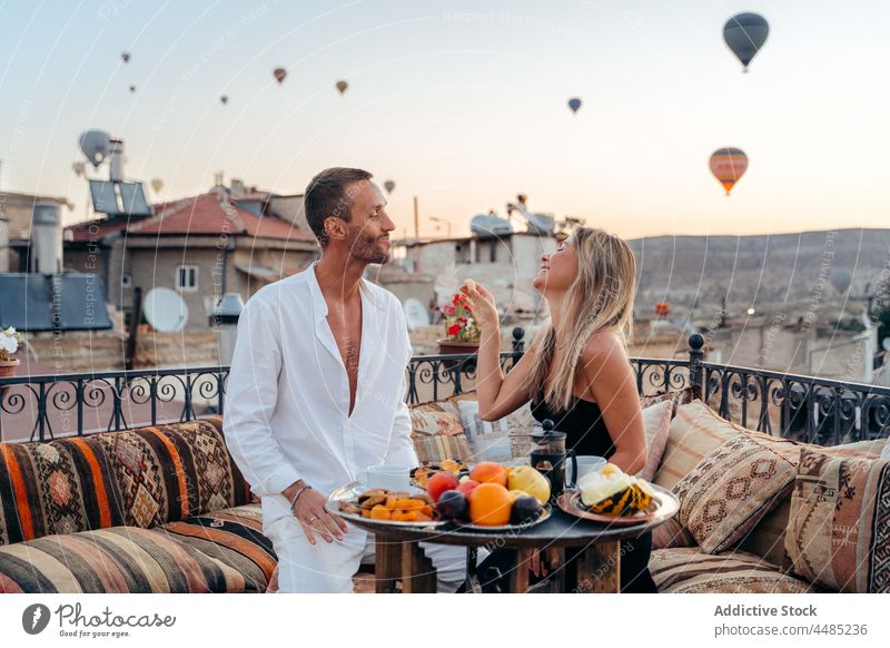 Glückliches Paar auf dem Dach gegen Heißluftballons Dachterrasse Termin & Datum romantisch Zusammensein Zuneigung Sonnenuntergang Ballone Partnerschaft