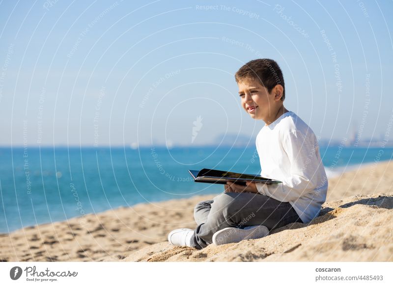Kleines Kind liest ein Buch am Strand Aktivität bezaubernd Herbst Rücken Junge Kaukasier Kindheit Großstadt Küste kreativ neugierig niedlich Tag Feiertag