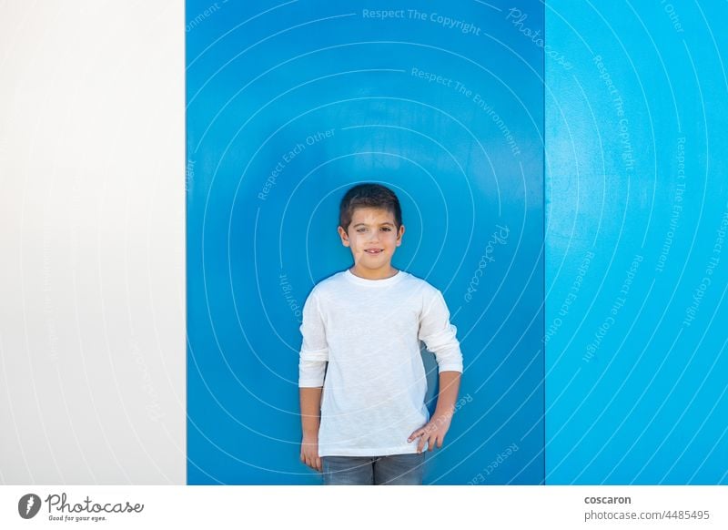 Hübscher Junge mit weißem T-Shirt auf blauem, schwarzem Grund attraktiv Hintergrund schön blond sorgenfrei Kaukasier heiter Kind Kindheit farbenfroh niedlich