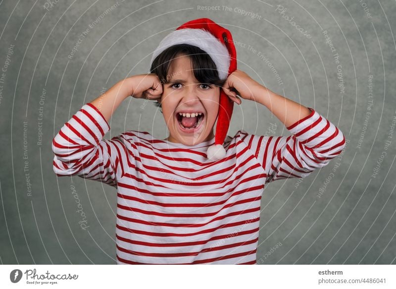wütendes Kind mit Weihnachtsmannmütze und Händen auf dem Kopf Weihnachten schreit verzweifelt Heiligabend verrückt gestresst Nervös Verzweiflung Frustration