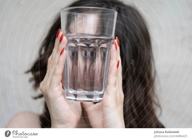 Frau sieht durch ein leeres Glas lecker genießen halten durchsichtig brünett Ernährung durstig Erfrischung Trinkwasser Mineralwasser Nahaufnahme Gesundheit kalt