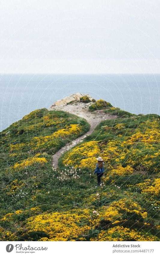 Anonyme Frau, die auf einer Klippe am Meer spazieren geht Reisender Blume MEER Küste Abenteuer Meeresufer Wasser Seeküste Ufer Hafengebiet Wasserseite