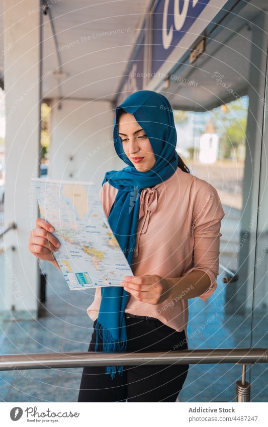Arabische Frau liest Papierkarte in der Stadt Landkarte lesen navigieren sich orientieren Großstadt Tourist Hijab Kopftuch Straße muslimisch arabisch ethnisch