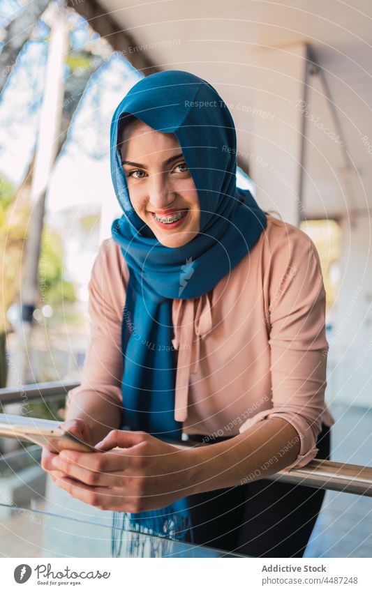 Muslimische Frau mit Smartphone Großstadt Browsen Hijab Lächeln Mobile Telefon ethnisch arabisch muslimisch Straße online Nachricht Internet heiter Surfen Gerät