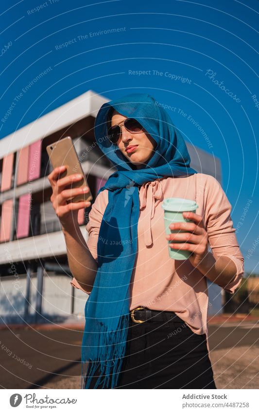 Elegante muslimische Frau, die in der Stadt auf ihrem Smartphone surft Nachricht Hijab Kaffee Imbissbude Browsen benutzend soziale Netzwerke Funktelefon